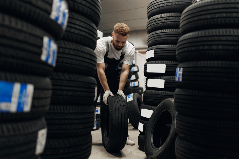 mechanic,man,holding,tire,in,repair,garage.,replacement,of,winter