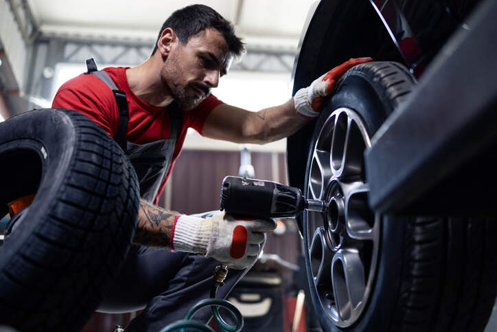 mechanic installing tyre car